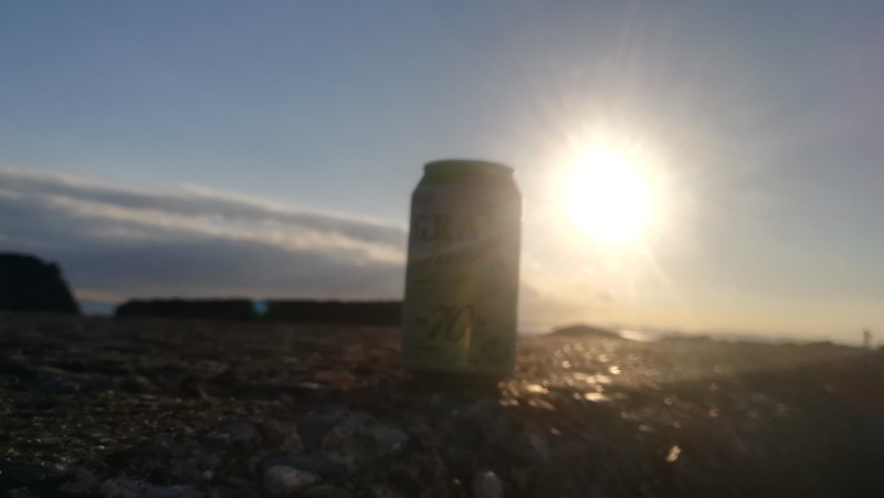 日が沈む夕日を背景にしたビール